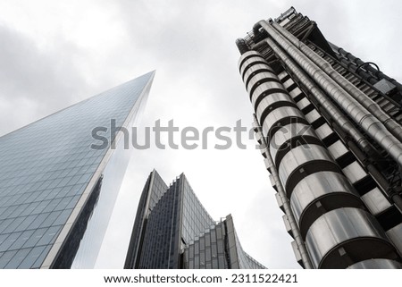 Three modern skyscrapers on the cloudy sky background.