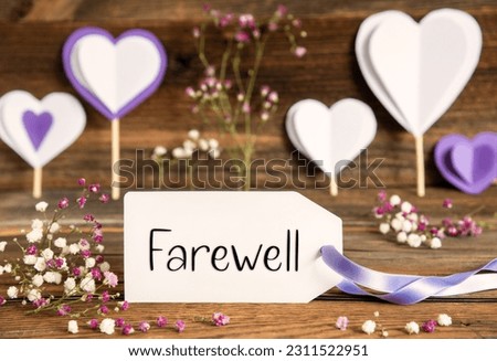 Label With English Text Farewell. Purple And Lilac Decoration And Spring Flower Arrangement. Heart Symbols With Wooden Background.