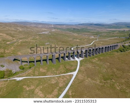 This aerial drone photo shows the old Ribblehead Viaduct. This railway bridge was built in 1875 and is still operating. The railway leads through the beautiful landscape of Yorkshire Dales, England.