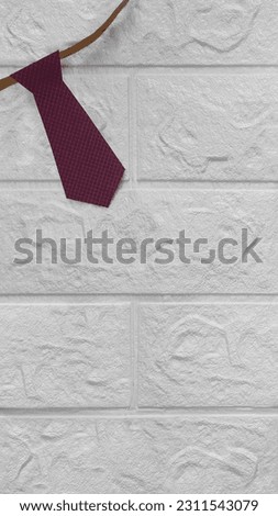 Burgundy necktie cut out of checkered paper. Place for text Tie on white brick wall background. Vertical photo. Copy space. Template for Father's Day, Love Your Lawyer Day, professional holiday.