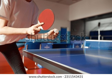 Closeup view of adult woman playing table tennis in gym Royalty-Free Stock Photo #2311543431