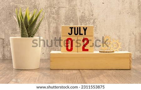 July 2 calendar date text on wooden blocks with blurred background park. Copy space and calendar concept.