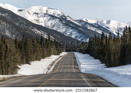 Stunning mountain views along the Alaska Highway in late winter early spring time with magnificent snow capped mountains road, street. Royalty-Free Stock Photo #2311582867