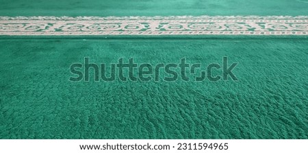 a picture, a dark green carpet with a combination of light brown motifs 