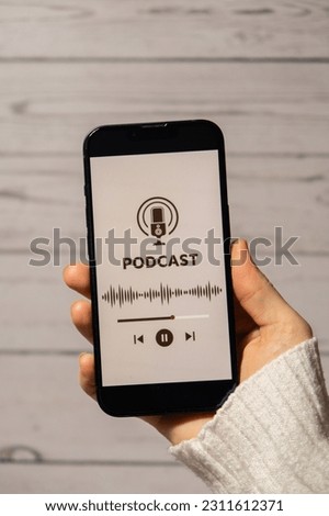 Unrecognizable woman holding mobile phone Podcast listening website page app application with wireless headphones. Audio healing, sound therapy wellness rituals, positive mental health habits