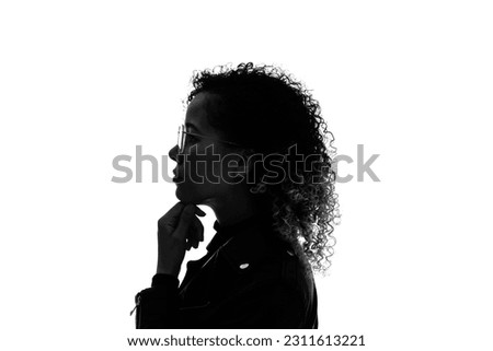 Profile silhouette of thinking black woman in studio shot. Royalty-Free Stock Photo #2311613221