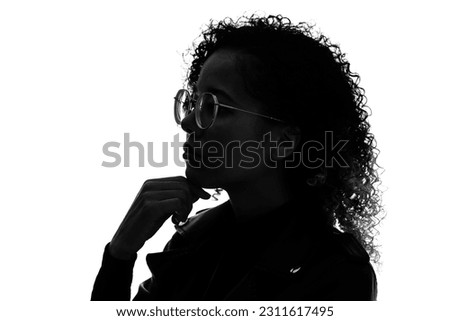 Profile silhouette of thinking black woman in studio shot. Royalty-Free Stock Photo #2311617495
