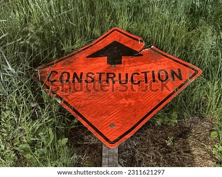 Construction sign laying in the grass on Rideau Street Ottawa Ontario Canada.