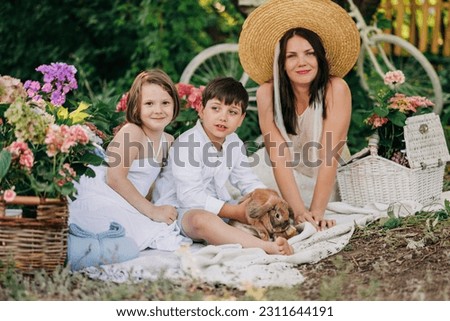Kids on picnic with rabbits or bunny at sumer or spring with blooming garden park. Happines on nature children
