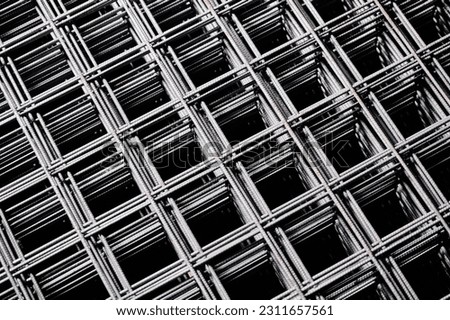 Stacked welded wire mesh in cold plant storehouse macro view Royalty-Free Stock Photo #2311657561