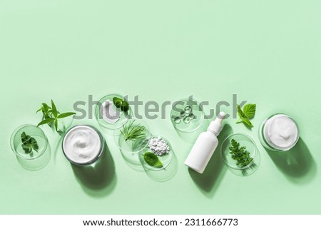 Organic skin care cosmetic products, natural plant ingredients on green background, copy space, banner. Bio science research, herbal skin care and eco lifestyle concept. Royalty-Free Stock Photo #2311666773