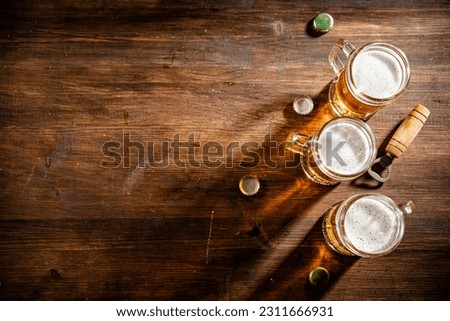 Glasses with fresh beer. On wooden background.