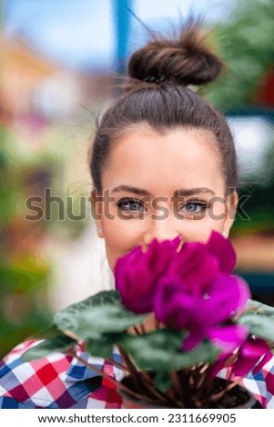 a beautiful blue-eyed flower girl holds purple flowers to the camera