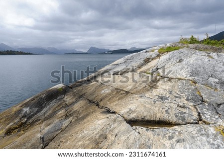rock formations by the sea and boats passing by Royalty-Free Stock Photo #2311674161