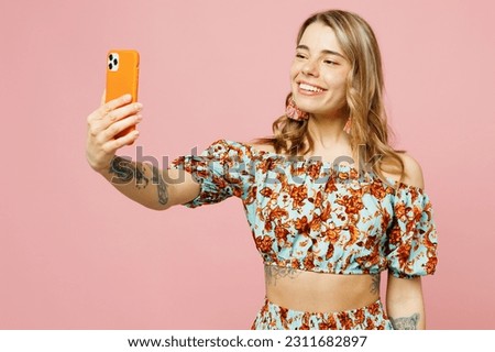 Young caucasian woman wear summer casual clothes doing selfie shot on mobile cell phone post photo on social network isolated on plain pastel light pink background studio portrait. Lifestyle concept