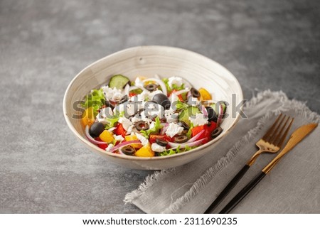 Greek salad of fresh cucumber, tomato, sweet pepper, arugula, red onion, feta cheese and olives with olive oil. Healthy food. Royalty-Free Stock Photo #2311690235
