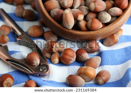 Hazelnuts in wooden bowl, on napkin background