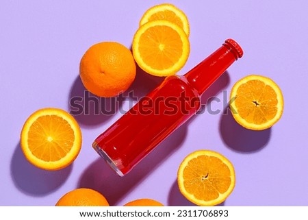 Composition with bottle of fresh soda and orange on purple background Royalty-Free Stock Photo #2311706893