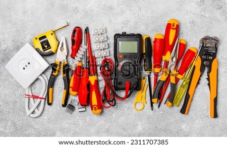 Electrician equipment on marble background with copy space.Top view.Electrician tool set.Multimeter, tester,screwdrivers,cutters,duct tape,lamps,tape measure and wires.Flet lay. Royalty-Free Stock Photo #2311707385