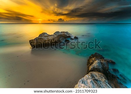 Beautiful sunset views all over the coast of the Mentawai Islands, West Sumatra, Indonesia. The waves are big for world-class surfers. White sandy beaches, boulders, and large cliffs, weathered wood Royalty-Free Stock Photo #2311709323