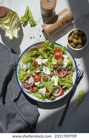 Greek salad with vegetables and cheese on a gray table