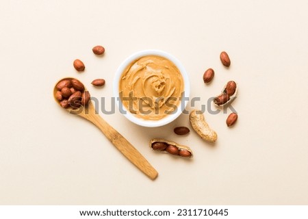 Bowl of peanut butter and peanuts on table background. top view with copy space. Creamy peanut pasta in small bowl. Royalty-Free Stock Photo #2311710445