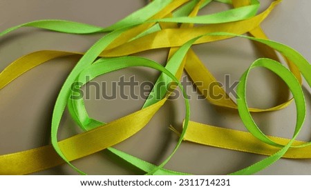 Yellow and green ribbons on a beige background. 