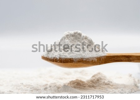 Powdered sugar on wooden spoon. Powdered sugar or icing sugar isolated on white background Royalty-Free Stock Photo #2311717953