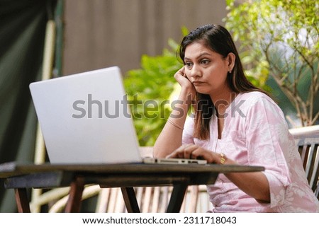 woman giving sad expression while looking in laptop. Royalty-Free Stock Photo #2311718043