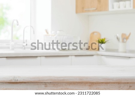 Wooden table top on blurred modern kitchen sink interior background