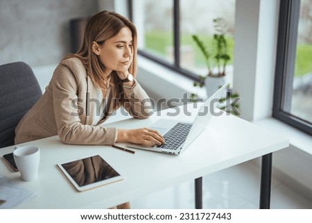 Shot of a young woman suffering from stress while using a computer at her work desk. Female entrepreneur with headache sitting at desk. The stress and tension are becoming too much to handle