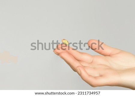 hand holding a vitamin capsule. taking vitamins and nutritional supplements for female beauty and health Royalty-Free Stock Photo #2311734957
