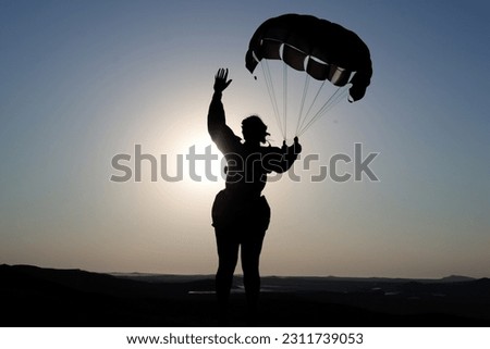 Silhouette of a person skydiving with a very beautiful light. Concept of extreme sports and perfect activities to do on vacation