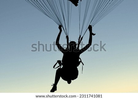 Silhouette of a person skydiving with a very beautiful light. Concept of extreme sports and perfect activities to do on vacation