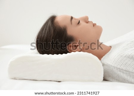 Woman sleeping on memory foam pillow indoors Royalty-Free Stock Photo #2311741927