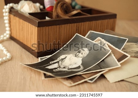 stack of old retro family sepia photos on table, vintage wooden box with dear heart memorabilia, concept of family tree, genealogy, home archive, memory of ancestors, childhood memories Royalty-Free Stock Photo #2311745597