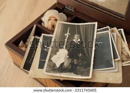 stack of old retro family sepia photos on table, vintage wooden box with dear heart memorabilia, concept of family tree, genealogy, memory of ancestors, home archive, childhood memories Royalty-Free Stock Photo #2311745605