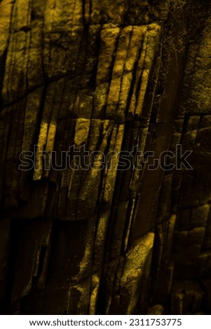 Cracked rock texture. Yellow golden stone background. golden highlight. Dark gray rough surface. enlargement. Background image of concrete shapes of broken, damaged, and collapsed stones