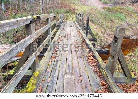 old wooden bridge over small river. autumn.