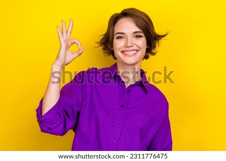 Photo of pretty promoter girl express agreement show okey symbol wear elegant blouse isolated yellow color background
