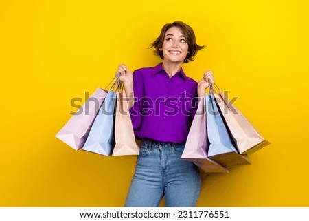Photo of fashionista lady wear shirt hold much bargains look empty space dreaming brand clothes sale isolated on yellow color background