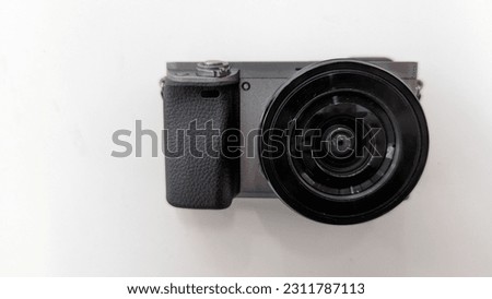 The mirrorless camera is photographed from above with a white background. A DSLR camera view from above