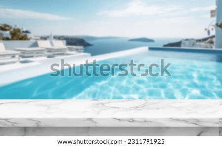 Marble table top for product placement with blurred background of a beautiful blue water pool, in a pretty Santorini stylish resort  Royalty-Free Stock Photo #2311791925