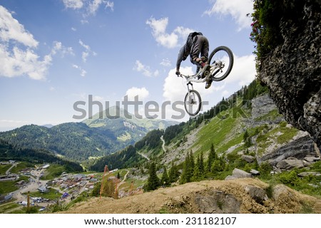 Mountainbiker jumping from a rock Royalty-Free Stock Photo #231182107
