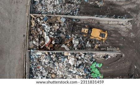 Landfill site, a pile of stinky different junk disposal in the concrete section for unsorted waste materials Royalty-Free Stock Photo #2311831459