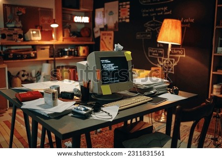 Horizontal image of workplace with computer with codes on the screen standing on table in garage Royalty-Free Stock Photo #2311831561