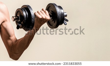 Skinny guy hold dumbbells up in hands. Thin man in sports with dumbbells. Weak man lift a weight, dumbbells, biceps, muscle, fitness. Man holding dumbbell in hand. Royalty-Free Stock Photo #2311833055