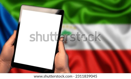 Man hold tablet phone pc gadget with white blank screen, copy space for text, image or message. Flag of Equatorial Guinea country on background. Technology, information, business
