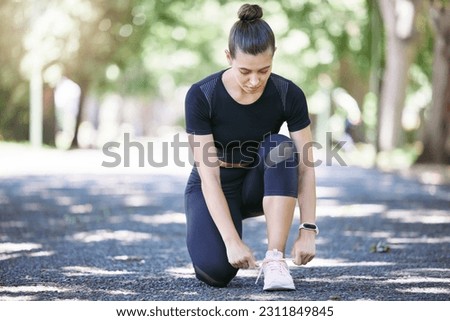 Fitness, woman tying her shoelaces and running outdoors at a nature park. Workout or exercise, training or health wellness and female person prepare to run outside for motivation with shoes.