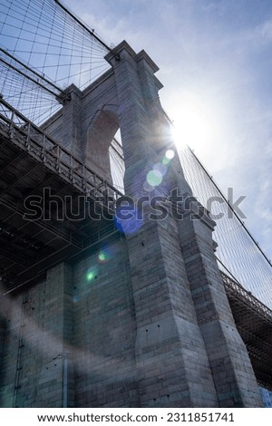 Brooklyn bridge with sun in background and lens flares in front